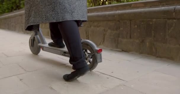 Zgrubne ujęcie żeńskich nóg na skuterze elektrycznym — Wideo stockowe