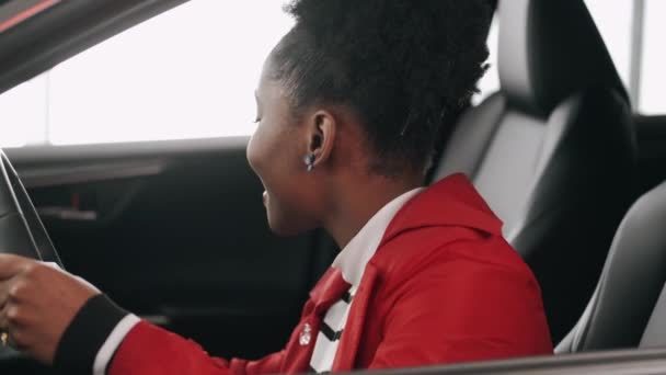 Αφροαμερικανή γυναίκα διαλέγει αυτοκίνητο σε κομμωτήριο και ελέγχει το κομμωτήριο — Αρχείο Βίντεο