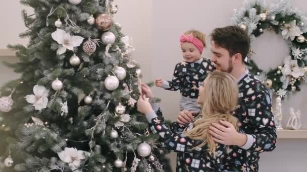 행복 한 가족 이 거실에 거품으로 크리스마스 트리를 장식하고 있다 — 비디오