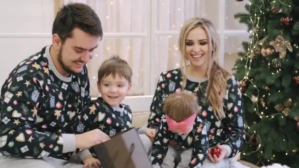 Família de quatro presentes de Natal desembrulhados perto da árvore de Natal — Vídeo de Stock