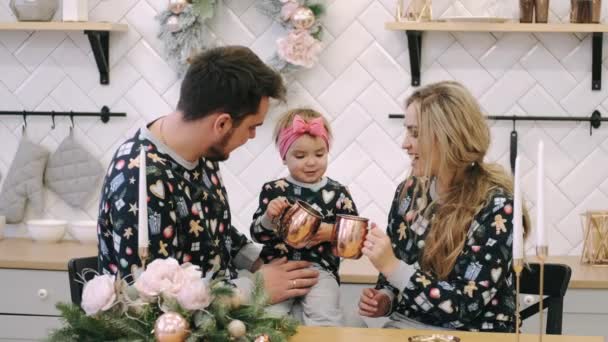 Молода сім'я в теплих светрах з дочкою в різдвяній спальні — стокове відео