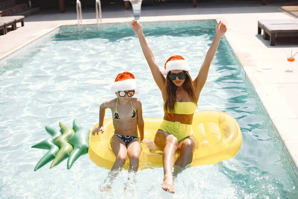 Matka i córka w Boże Narodzenie kapelusze w basenie — Zdjęcie stockowe