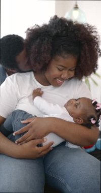 Afrikalı genç bir aile kızıyla evde oynuyor.