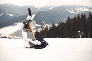 Dağlarda snowboard yapan bir kız.