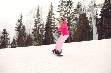 Dağlarda snowboard yapan bir kız.
