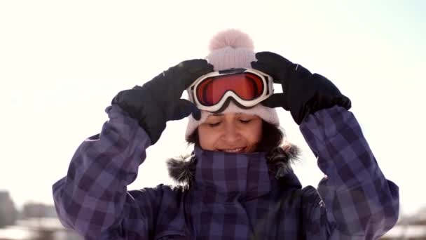 Mujer snowboarder ponerse gafas en la estación de esquí antes de esquiar — Vídeo de stock