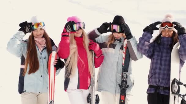 Mulheres snowboarders e esquiadores na encosta da montanha falando e relaxando após slide — Vídeo de Stock