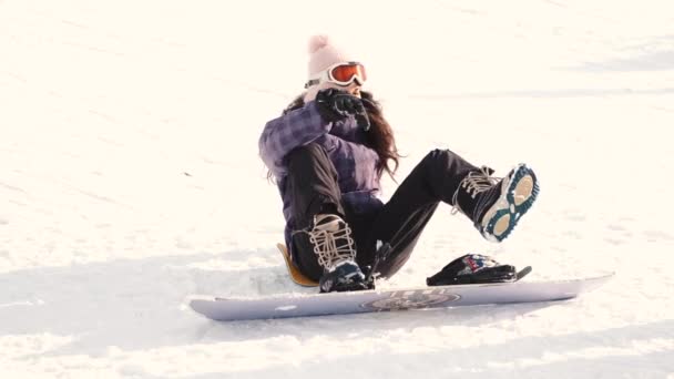 Γυναίκα snowboarder βάζει σε ένα snowboard από κοντά — Αρχείο Βίντεο