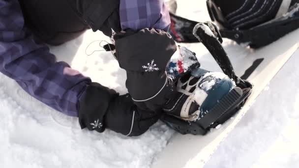 Mujer snowboarder pone en una tabla de snowboard de cerca — Vídeo de stock