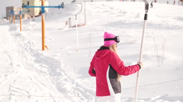 Mooie jonge Europese vrouw in materiaal op skigebied — Stockvideo