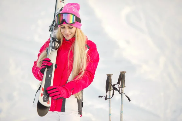 Chica esquiando en las montañas en un traje de esquí rosa y blanco — Foto de Stock