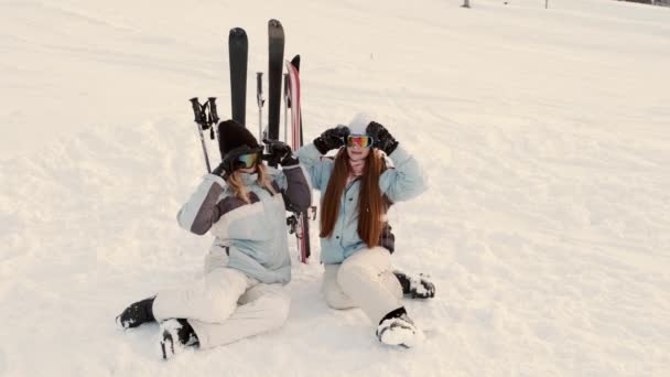 Dos hermosas mujeres jóvenes riendo en la estación de esquí — Vídeo de stock