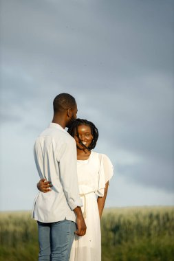 Mutlu romantik çift yaz tarlasında sarılıyor.