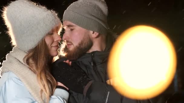 Un couple séduisant amoureux, un couple élégant portant des vêtements chauds câlinant ensemble et se regardant à la foire d'hiver à une période de Noël — Video