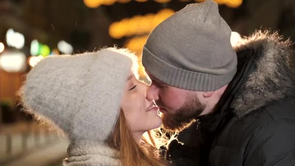 Un couple séduisant amoureux, un couple élégant portant des vêtements chauds câlinant ensemble et se regardant à la foire d'hiver à une période de Noël — Video
