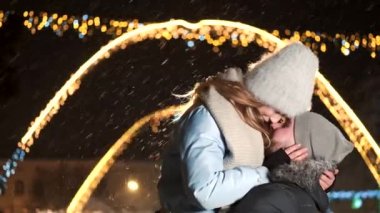 Çekici bir çift aşık, birlikte sarılma ve Noel zamanda adil kış birbirlerine bakarak şık çift giyen sıcak giysiler