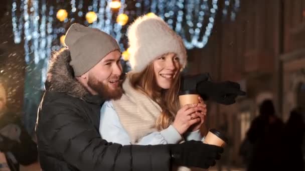Jeune couple dans la ville pendant Noël boire du café chaud — Video