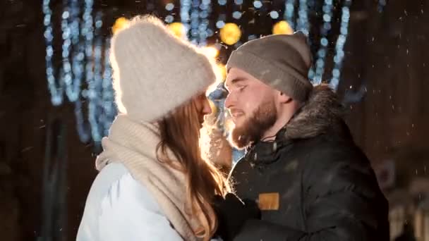 Un couple séduisant amoureux, un couple élégant portant des vêtements chauds câlinant ensemble et se regardant à la foire d'hiver à une période de Noël — Video