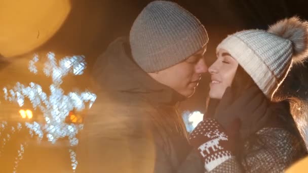 Νεαρό ζευγάρι φιλιά στην περιοχή διακοπών χειμώνα φωτισμό τη νύχτα — Αρχείο Βίντεο