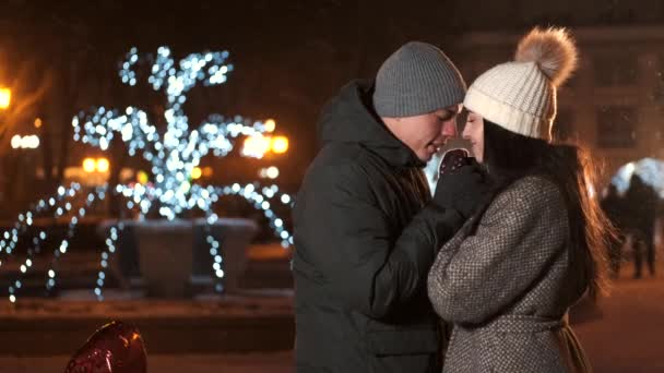 Młoda para całuje w wakacje zimowe oświetlenia w nocy — Wideo stockowe