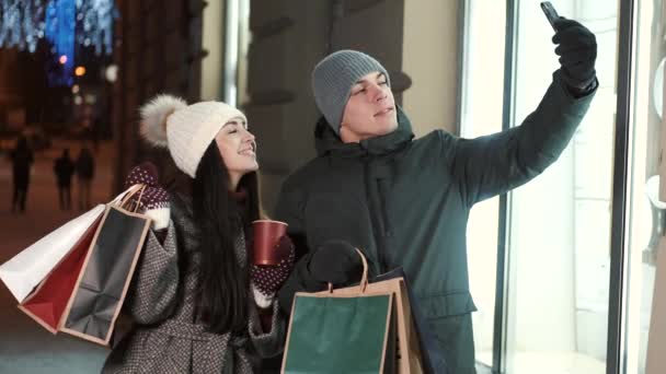 Twee mensen paar studenten nemen selfie op smartphone in kerst versierde stad — Stockvideo