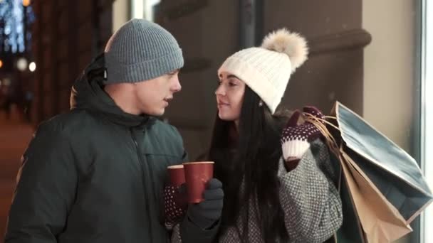 Dwoje kochających ludzi w parze z gorącym napojem w dłoniach spędzających razem świąteczny wieczór — Wideo stockowe