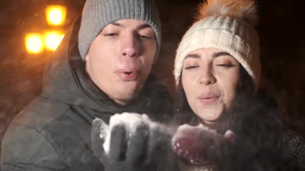 На відкритому повітрі зйомки молодої щасливої красивої пари дме сніг — стокове відео