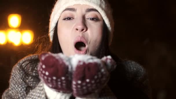 Joyeux jeune femme soufflant la neige à la foire d'hiver — Video