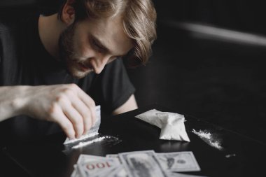 Genç bağımlı adam kokaini dolarla alıyor.