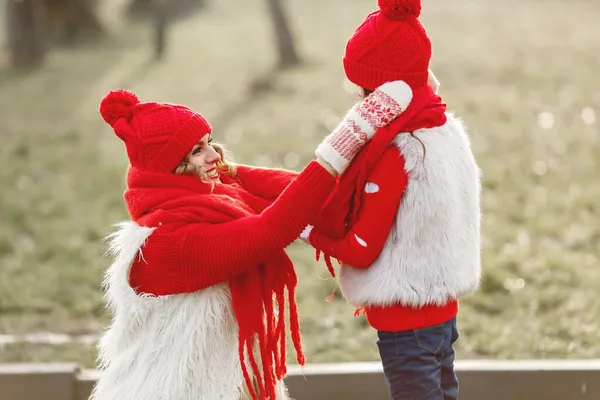 Mãe e criança em chapéus de inverno de malha jogar no parque de inverno — Fotografia de Stock