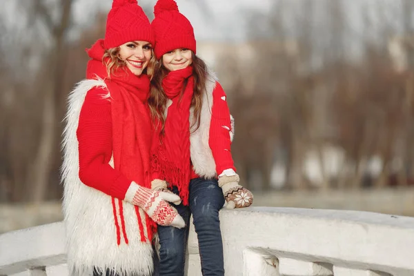 Matka i dziecko w dzianinach czapki zimowe bawić się w parku zimowym — Zdjęcie stockowe