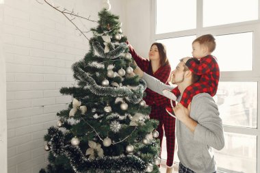 Noel ağacının yanında küçük oğlu olan bir aile.