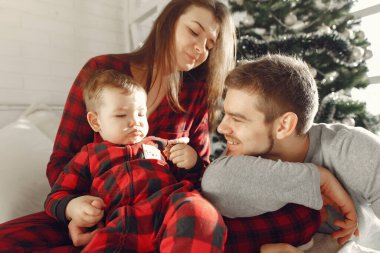 Güzel bir aile yatakta oturuyor, sarılıyor ve kurabiye yiyor.