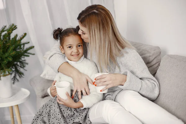 Kaukasische Mutter mit kleiner afrikanischer Tochter zu Hause — Stockfoto