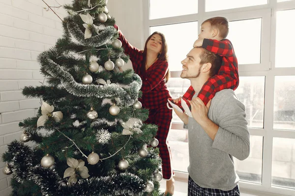 Familia con hijo pequeño en casa cerca del árbol de Navidad — Foto de Stock