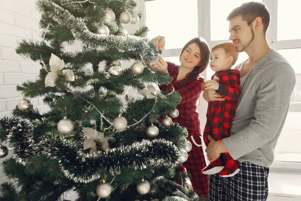 Familia con hijo pequeño en casa cerca del árbol de Navidad — Foto de Stock