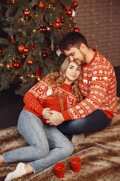 Söta par sitter hemma nära julgran — Stockfoto