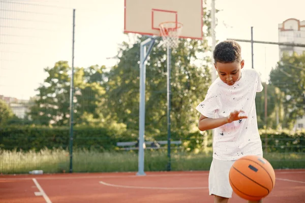 多种族男孩站在篮球场上玩橙色球 — 图库照片