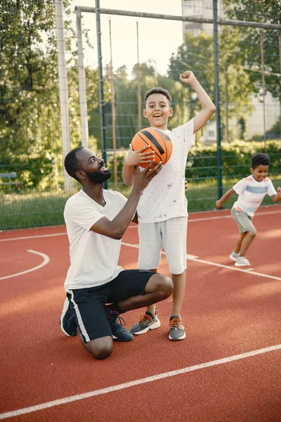 黑人父亲和他的多种族儿子一起站在篮球场上 — 图库照片