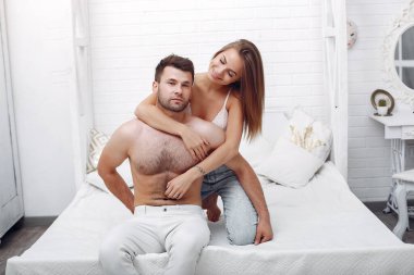 Bir çift bir odada yatakta yatıyor.