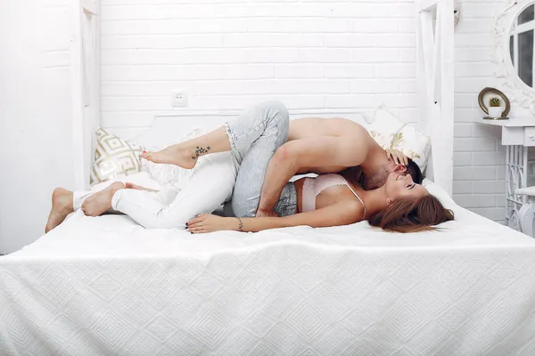 Casal deitado em uma cama em um quarto — Fotografia de Stock