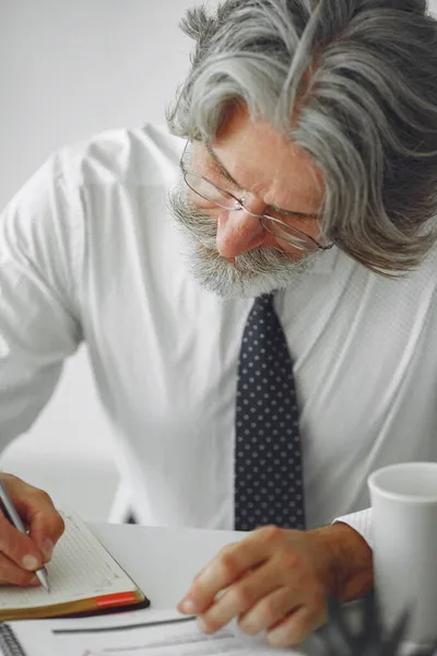 Knappe pensive volwassen zakenman zitten in het kantoor — Stockfoto