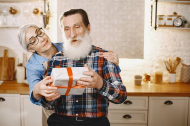 Mutfakta hediyeleri olan yaşlı bir çift.