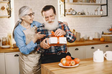 Mutfakta hediyeleri olan yaşlı bir çift.