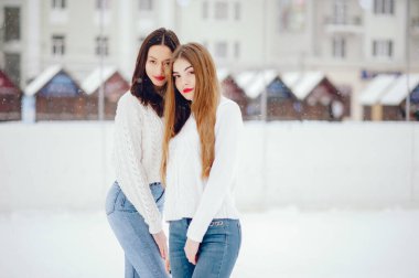 Kış parkında duran beyaz kazaklı genç kız.