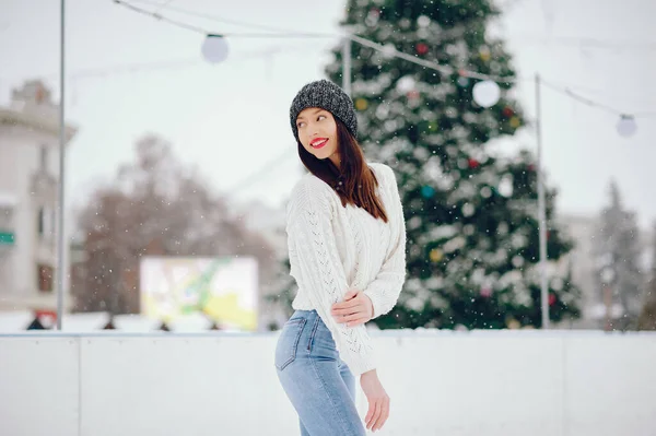 Νεαρό κορίτσι με λευκό πουλόβερ στέκεται σε ένα χειμερινό πάρκο — Φωτογραφία Αρχείου