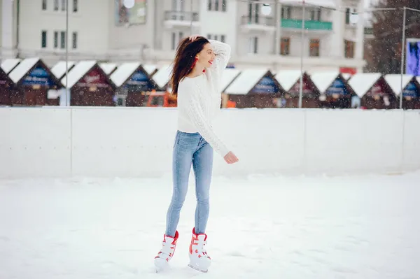 Söt och vacker flicka i en vit tröja i en vinterstad — Stockfoto