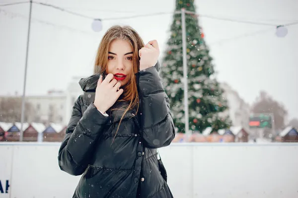 Chica joven en un suéter blanco de pie en un parque de invierno — Foto de Stock