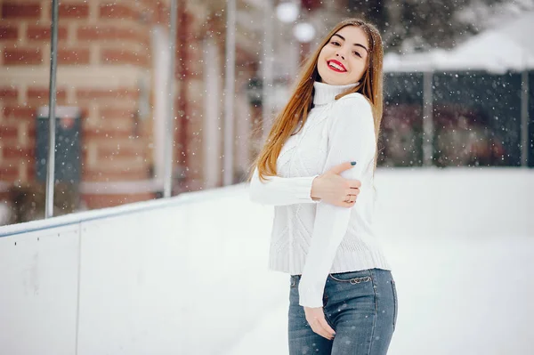 Jeune fille dans un pull blanc debout dans un parc d'hiver — Photo