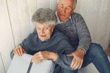 Zarif yaşlı çift Noel hediyeleriyle evde oturuyor.